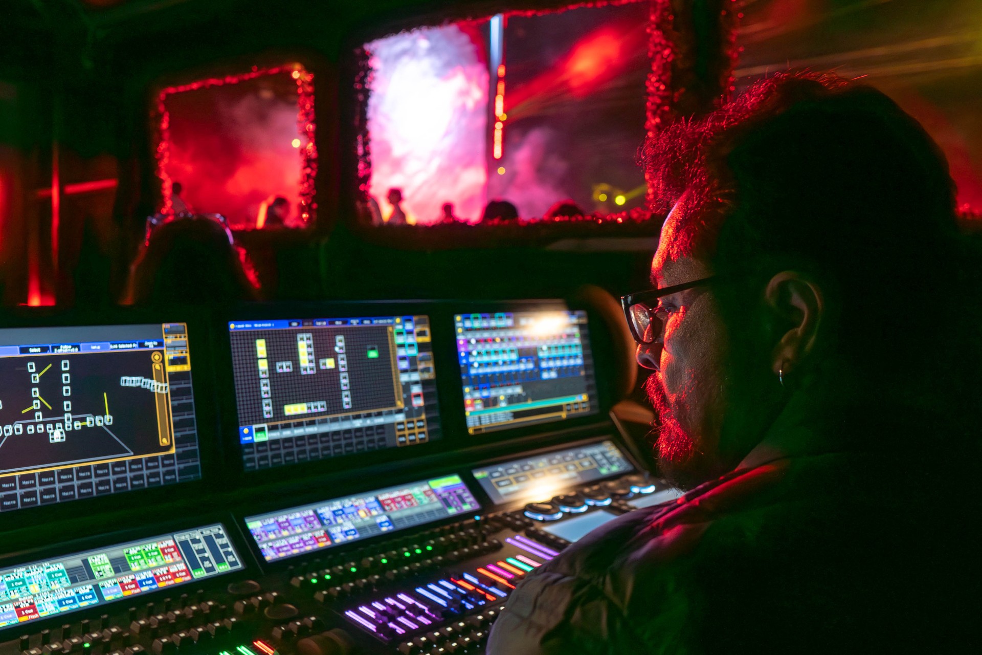 Lighting director running the live show from the console under red light.