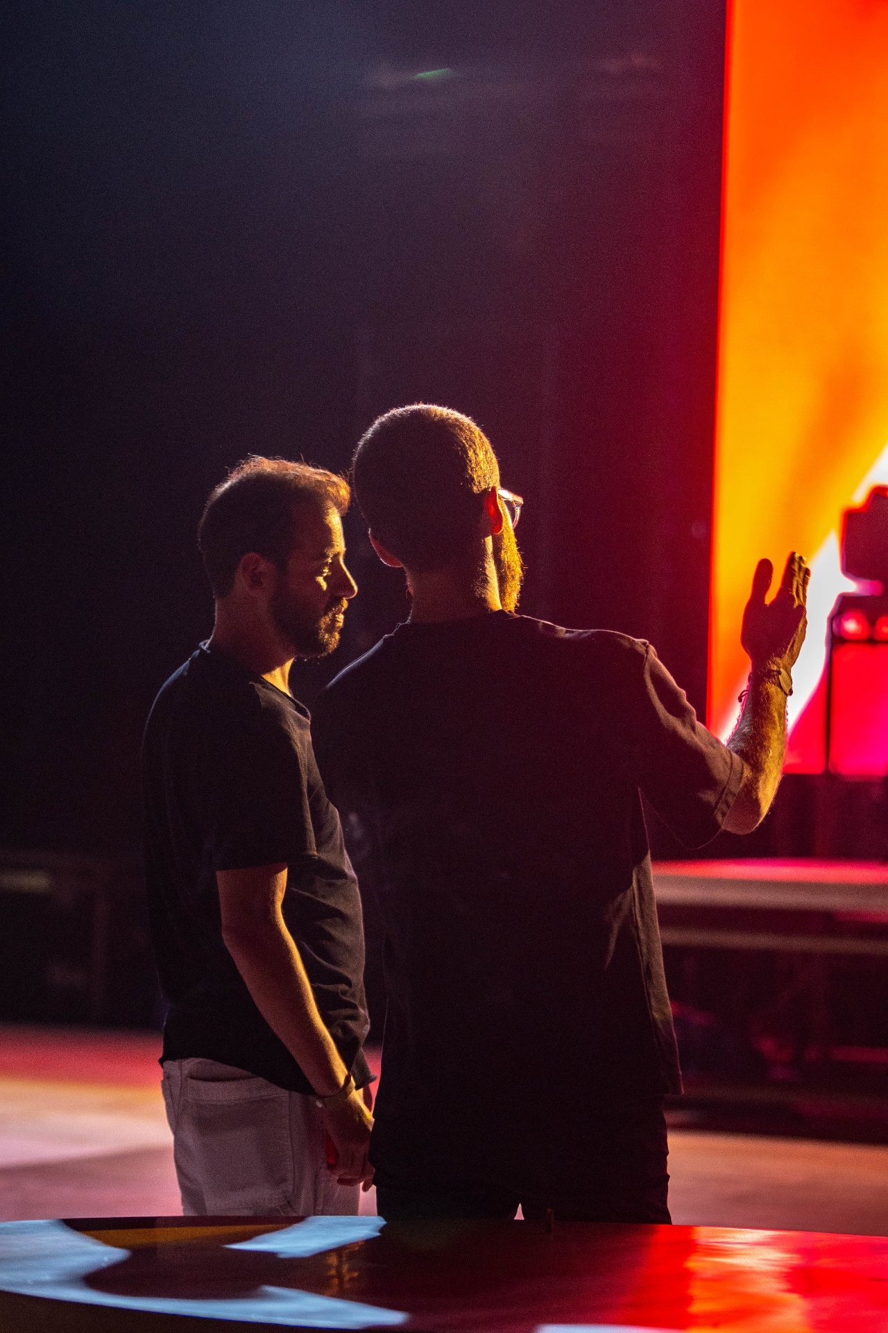 Creative direction on stage during rehearsal under red light.