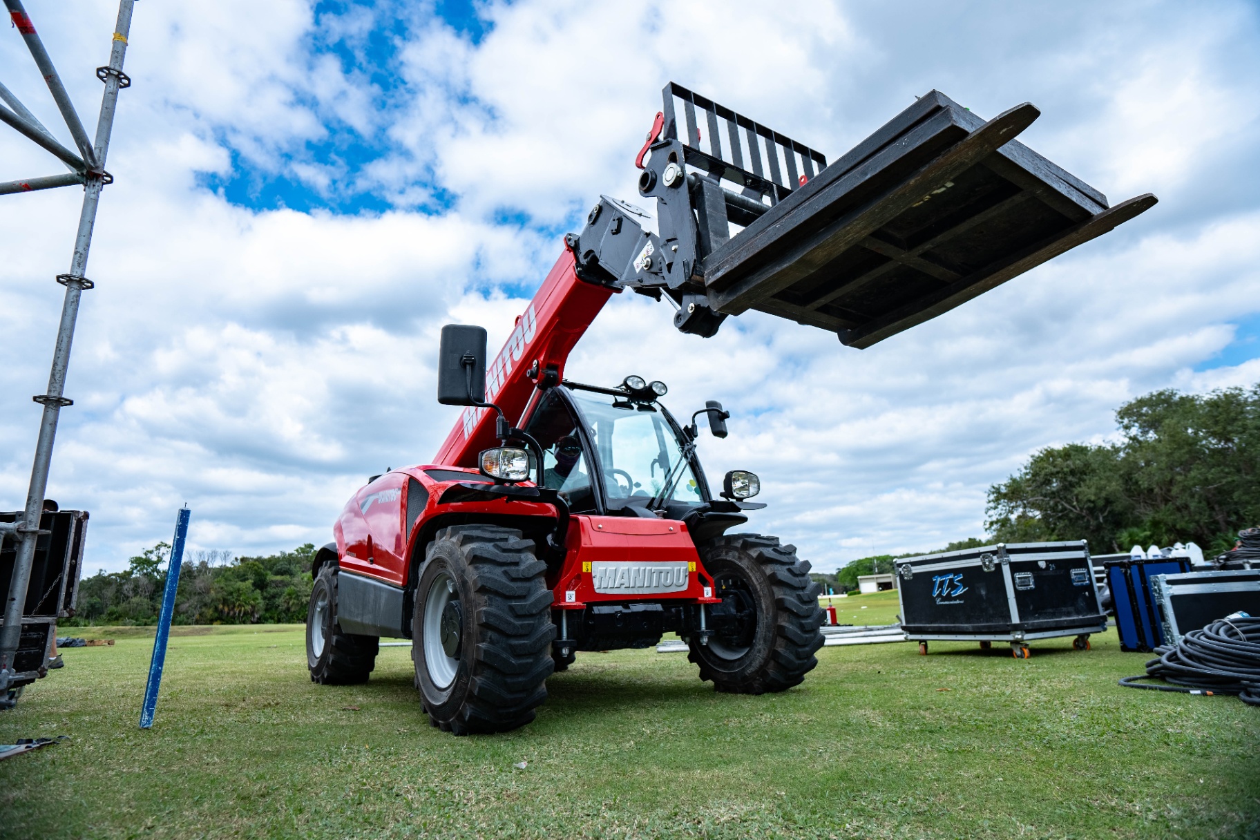 Telehandler lifting staging materials across the venue.