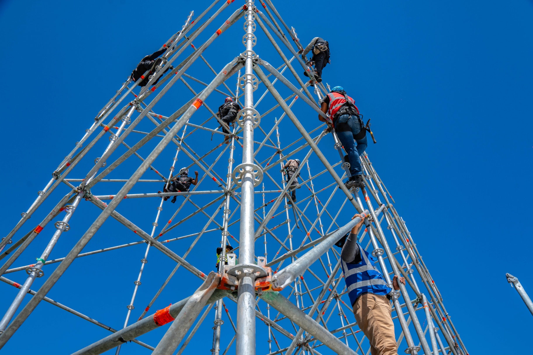 Riggers climbing the scaffolding structure during build-up.